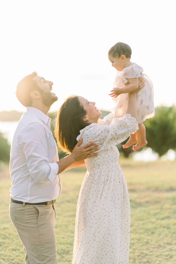 Mom lifts baby girl up during a family photography session in Dallas Tx