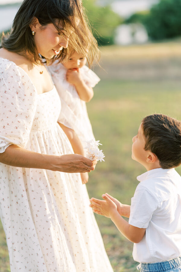 Son hands mom flowers during a family session