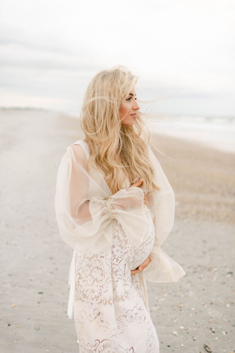 pregnant mama walking on the beach at sunset photographed by Chelsea Hollis in Wilmington, NC