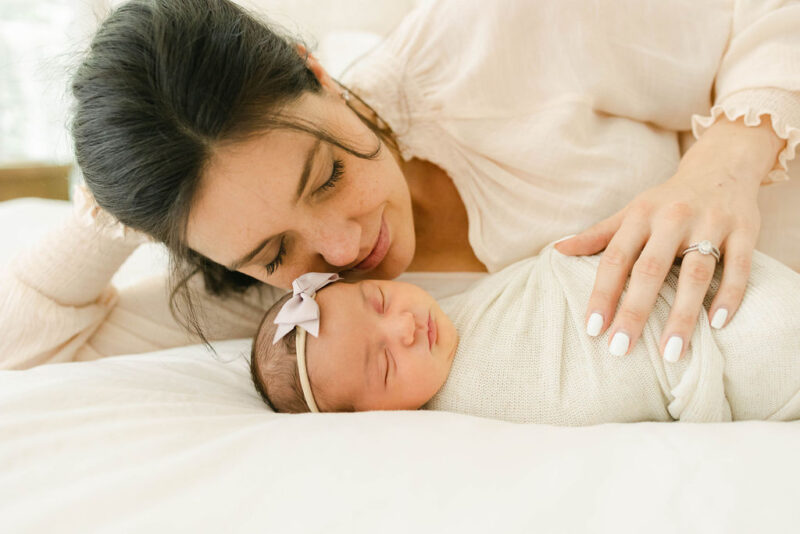 newborn baby and mama snuggled on the bed photographed by Chelsea Hollis in Wilmington, NC