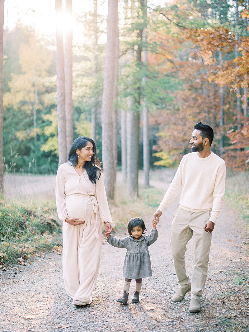 outdoor maternity photography session Ontario Canada motherhood anthology feature family walking in the woods