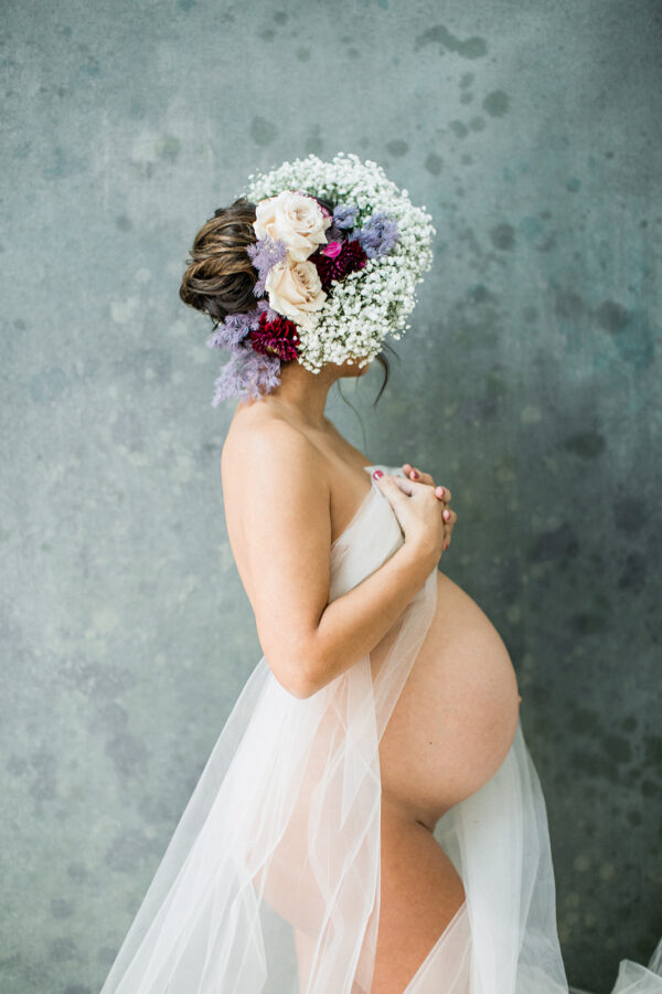 floral filled maternity session in studio photographed by Rooted Love Photography in Orlando, FL featured on The Motherhood Anthology blog