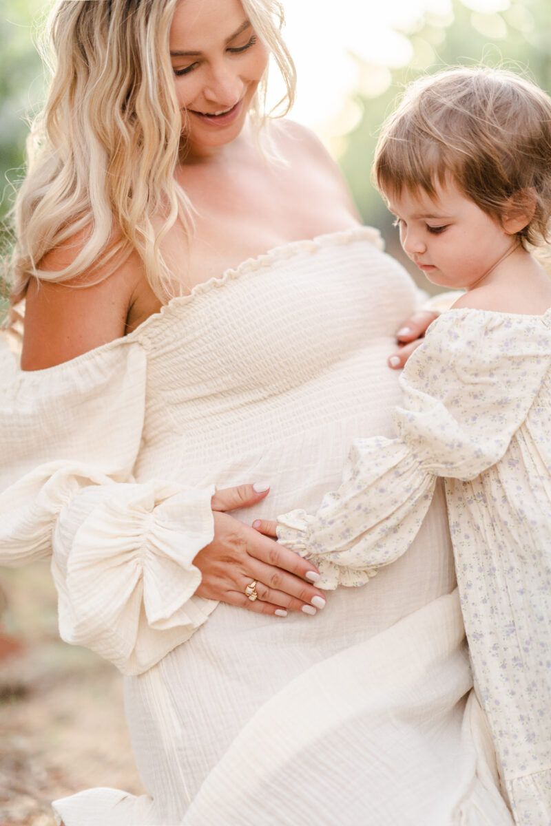 mom and baby touching pregnant belly in Bay Area California photographed by amber Courtney owner of light livin photography