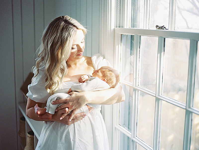 mom + newborn baby in home lifestyle session all white neutral photographed by Morgan Williams Photo in Raleigh, NC featured on The Motherhood Anthology blog