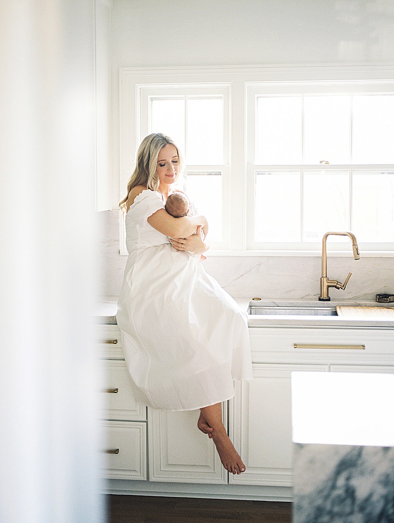 mom + newborn baby in home lifestyle session all white neutral photographed by Morgan Williams Photo in Raleigh, NC featured on The Motherhood Anthology blog