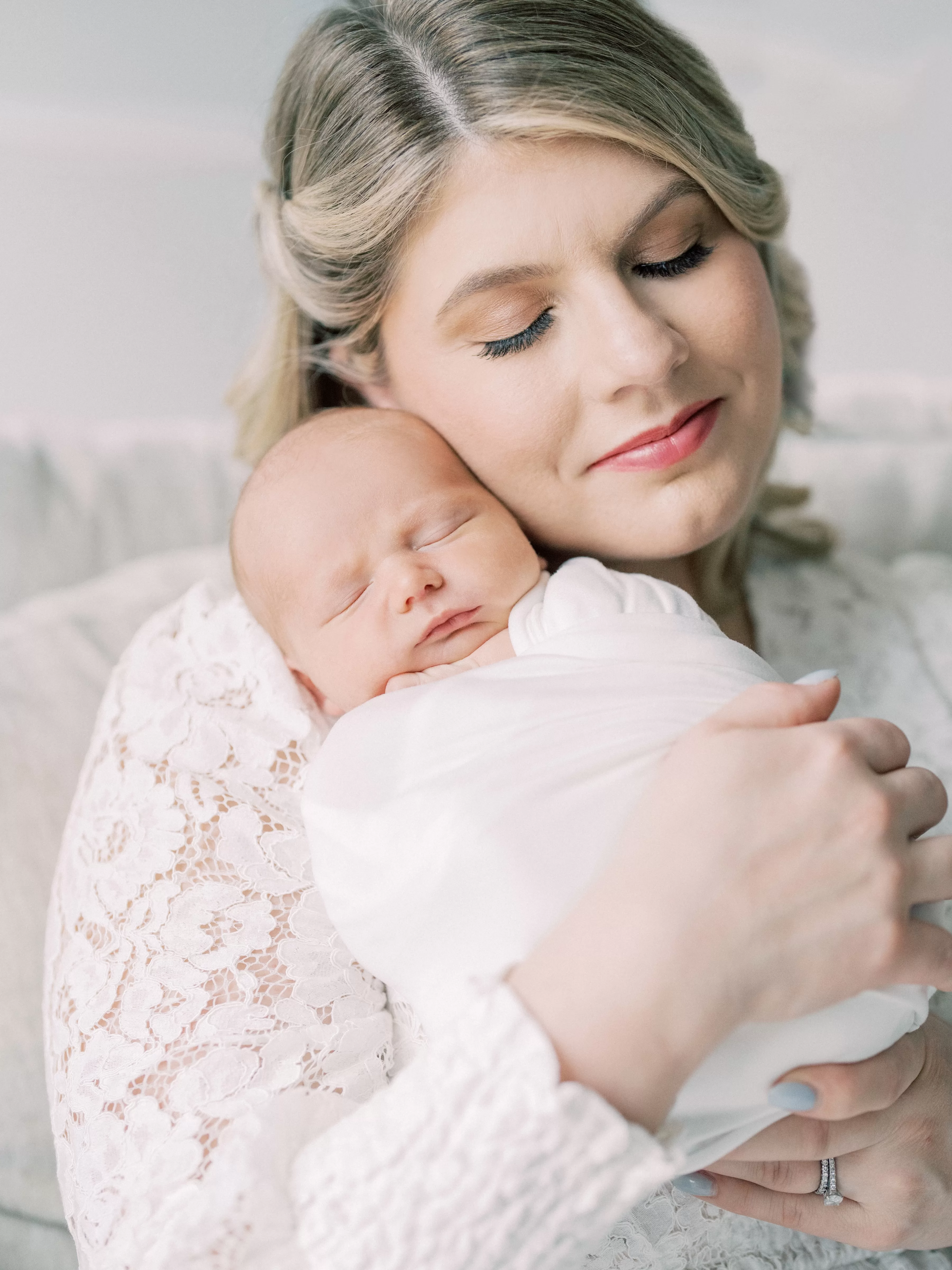 a loving mother cradles her newborn baby for her photography session